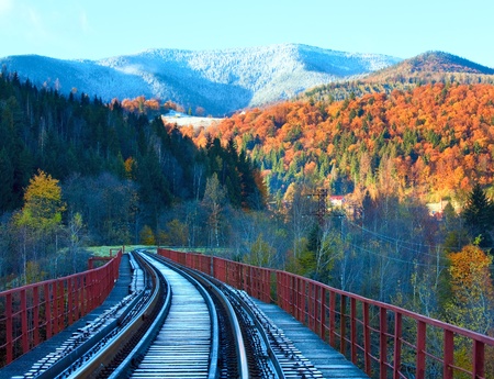 Railway on bridge and first autumn snow on far mountainsの写真素材