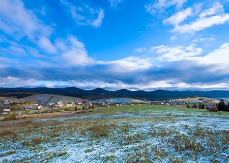 October Carpathian mountain plateau with first winter snow and village