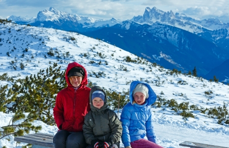 Family (mother with  two children) take a walk on winter mountain slope (view from Rittner Horn, Italy)の写真素材