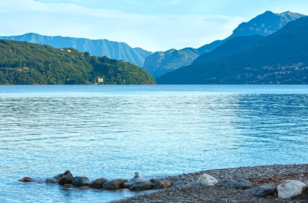 Lake Como (Italy) summer cloudy evening view with stony shore