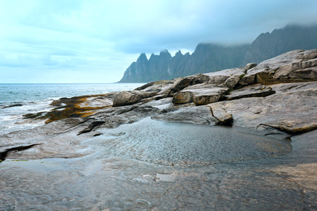 Summer night coast. The dragon's teeth rock, Jagged Ersfjord, Senja, Norway .の写真素材