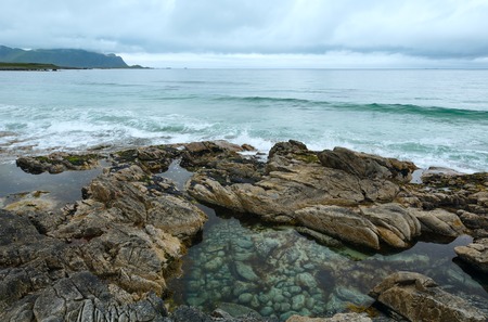 Summer cloudy view of the beach with pool in middle of stones ( Ramberg, Norway, Lofoten).の写真素材
