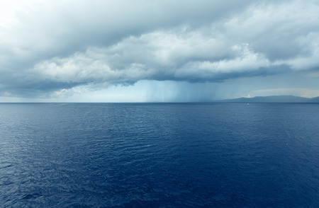 Sea summer view (with stormy sky and rain on horizon) from train ferry on way from Kefalonia to...