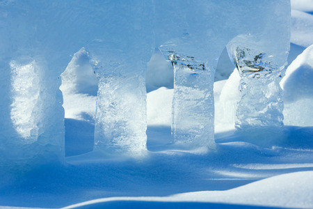 Transparent columns of ice on the snow illuminated by the spring sunshine.