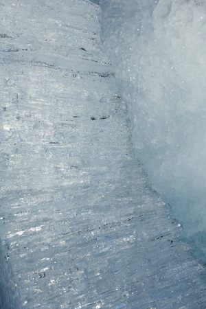 Glacial block of ice with interesting structure crystals macro. Winter background.