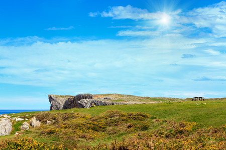 Resting place (table with benches) on summer sunshining sea coast near Camango, Asturias (Spain).の写真素材