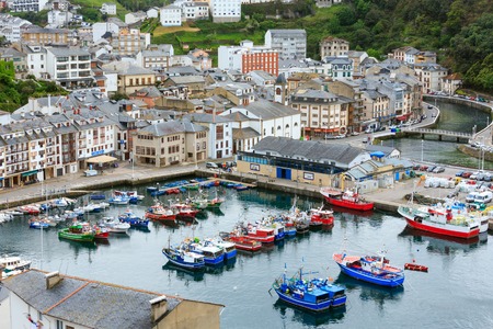 LUARCA, SPAIN -  MAY 10, 2016: Evening Luarca cityscape (top view) with colorful boats in fishing port, Asturias, Spain.のeditorial素材