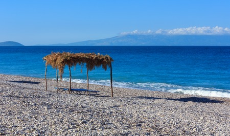 Summer morning pebbly beach with sunbeds and canopy (Borsh, Albania).の写真素材