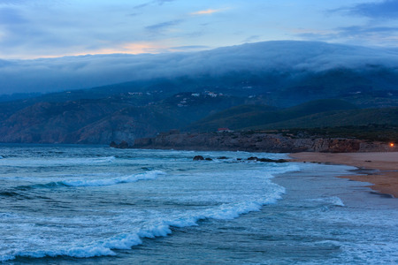 Sunset summer Atlantic Ocean rocky coast with sandy beach (Guincho, Portugal).の写真素材