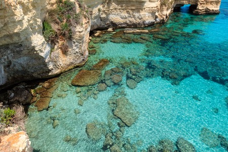 Picturesque seascape with cliffs, rocky arch and stacks (faraglioni), at Torre Sant Andrea, Salento sea coast, Puglia, Italyの写真素材