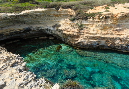 Picturesque seascape with white rocky cliffs and sea bay (Grotta dello Mbruficu, Salento Adriatic sea coast, Puglia, Italy).の写真素材