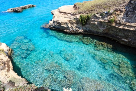 Picturesque seascape with white rocky cliffs, sea bay and islets at Grotta dello Mbruficu, Salento Adriatic sea coast, Puglia, Italyの写真素材