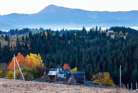 Early morning misty autumn slopes of Carpathians and mountain village (Yablunytsia village and pass, Ivano-Frankivsk oblast, Ukraine). Petros mount in far.のeditorial素材