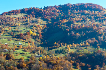 Autumn Carpathian Mountains landscape with multicolored trees and mountain village outskirts on slope (Rakhiv district, Transcarpathia, Ukraine).の写真素材