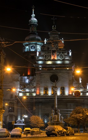 Night winter Lviv city (Ukraine) illuminated cityscape. Bernardine Church and monastery (church of St. Andrew) top, built in17th century. And Monument to Saint John of Dukla ahead, built in 1736.の写真素材