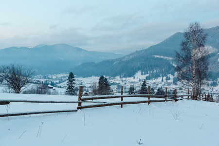 Daybreak morning dusk winter Carpathian mountain village Zelene in Black Cheremosh river valley between alp. View from rural snow covered path on hill slope, Verkhovyna district, Ukraine.の写真素材