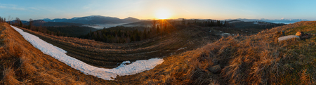 Early morning spring Carpathian mountains plateau landscape with snow-covered ridge tops in far, Ukraine.の写真素材