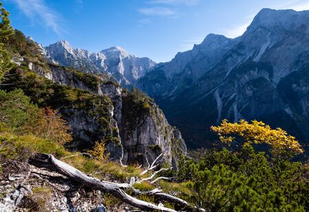 Sunny idyllic colorful autumn alpine scene. Peaceful rocky mountain view from hiking path near...