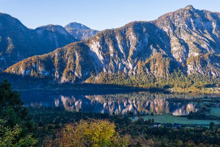 Idyllic morning colorful autumn alpine view. Peaceful mountain lake with clear transparent water and reflections. Hallstatter lake, Upper Austria.の写真素材