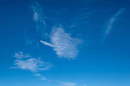 White fluffy cirrus and cirrocumulus clouds in deep blue azure sky. Summer good weather concept background.の写真素材