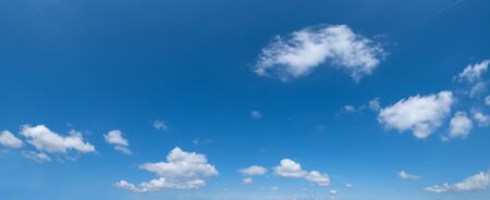 White fluffy altocumulus and cirrocumulus clouds in deep blue azure sky. Summer good weather concept background.の写真素材