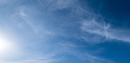 White fluffy cirrus and cirrocumulus clouds in deep blue azure sky. Summer good weather concept background.の写真素材