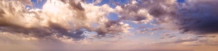 Summer sunset sky panorama with clouds. Summer evening cloudscape background.