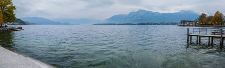 Autumn Alps mountain lake Mondsee misty view, Seepromenade Mondsee, Salzkammergut, Upper Austria....