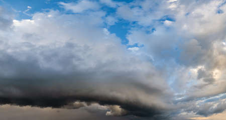 Dramatic cloudy sky with circular thunderstorm cloud. Natural weather and climate sky panoramic background scene.の写真素材