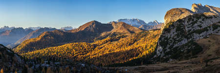 Sunny colorful autumn alpine Dolomites rocky mountain scene, Sudtirol, Italy. Peaceful view from Falzarego Pass. Snowy Marmolada massif and Glacier in far.の写真素材