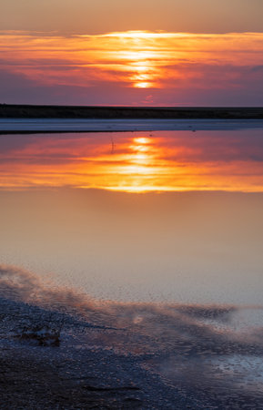 Sunset on the Genichesk pink extremely salty lake (colored by microalgae with crystalline salt depositions), Ukraine.の写真素材
