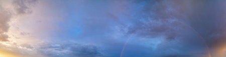 Summer sunset after rain sky panorama with fleece purple clouds and rainbow. Evening dusk good...