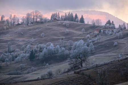 Winter coming. Last good weather days in autumn mountains countryside morning peaceful picturesque scene. Dirty road from hills to the village.の写真素材
