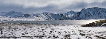 Season change in the Icelandic highlands.  Colorful Landmannalaugar mountains under snow cover in autumn. Frostastadavatn lake at the foot of the mountains.の写真素材