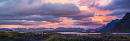 Sunrise Stokksnes cape sea beach, Iceland. Amazing nature scenery, popular travel destination. Autumn grass on black volcanic sand dunes.の写真素材