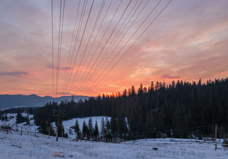 Small alpine village and winter snowy mountains in first sunrise sunlight around, Voronenko, Carpathian, Ukraine.の写真素材