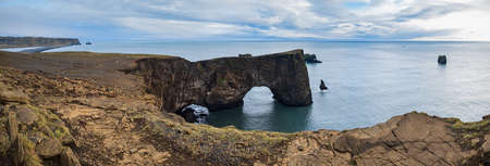 Picturesque autumn evening view to Dyrholaey coast cliffs and rocky arch, Vik, South Iceland....