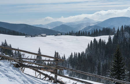 Winter remote alpine mountain village outskirts, countryside hills, groves and farmlands.の写真素材