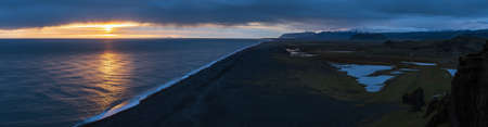 Picturesque autumn evening view to endless ocean  black volcanic sand beach from Dyrholaey Cape Viewpoint, Vik, South Iceland.の写真素材