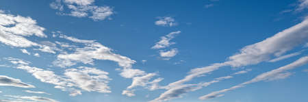 Blue sky with clouds in sunshine (wide natural cloudscape background panorama)