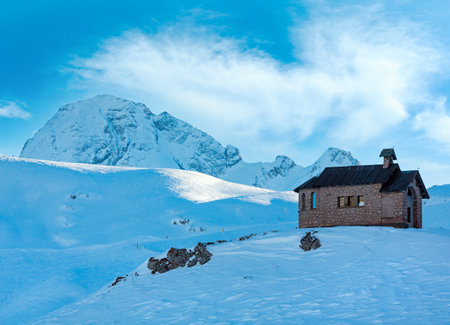Beautiful winter mountain view  from Pordoi Pass (Italian Dolomites ) with chapel on hill top.の写真素材