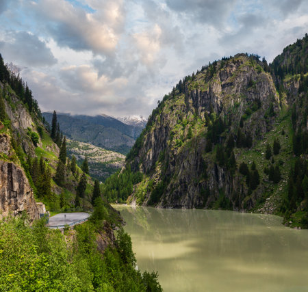 Summer Alps mountain landscape with turbid water reservoir lake and steep rocky slopes, Switzerlandの写真素材
