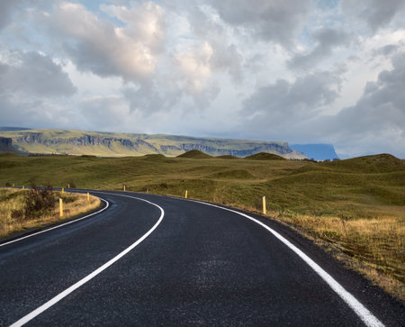 Highway road and mountain view during auto trip in Iceland. Spectacular Icelandic landscape with  scenic nature: fjords, fields, clouds, glaciers, waterfalls.の写真素材