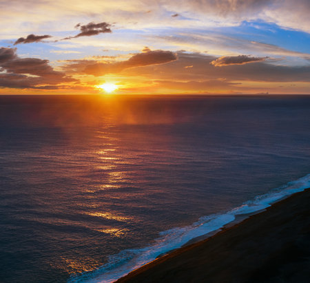 Picturesque autumn evening view to endless ocean  black volcanic sand beach from Dyrholaey Cape, Vik, South Iceland. Vestmannaeyjar islands weird silhouettes on horizont.の写真素材