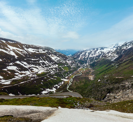 Spring cloudy overcast mountain landscape with serpentine road on Furka Pass, Switzerland.の写真素材