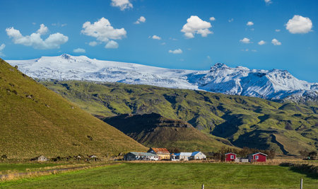 View from highway road during auto trip in Iceland. Spectacular Icelandic landscape with  scenic nature: hamlets, mountains, ocean coast, fjords, fields, clouds, glaciers, waterfalls.の写真素材
