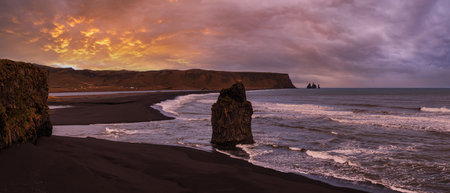 Picturesque autumn evening view to Reynisfjara ocean  black volcanic sand beach and rock formations from Dyrholaey Cape, Vik, South Iceland. Mount Reynisfjall on the background.の写真素材