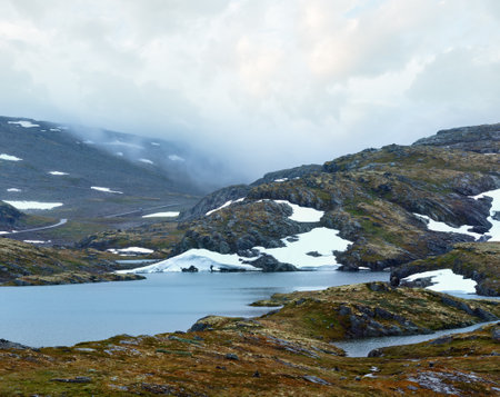 Summer mountain misty landscape with lake and snow (Norway, Aurlandsfjellet).の写真素材