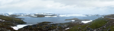 Dense fog and summer mountain landscape with lake and snow (Norway, not far Nigardsbreen glacier). Panorama.の写真素材