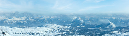 Winter hazy view from Dachstein mountain massif top and house on rocky slope (Austria).の写真素材